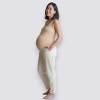 Celviroa beige ribbed maternity tank top and cream maternity pants, worn by a smiling pregnant woman.